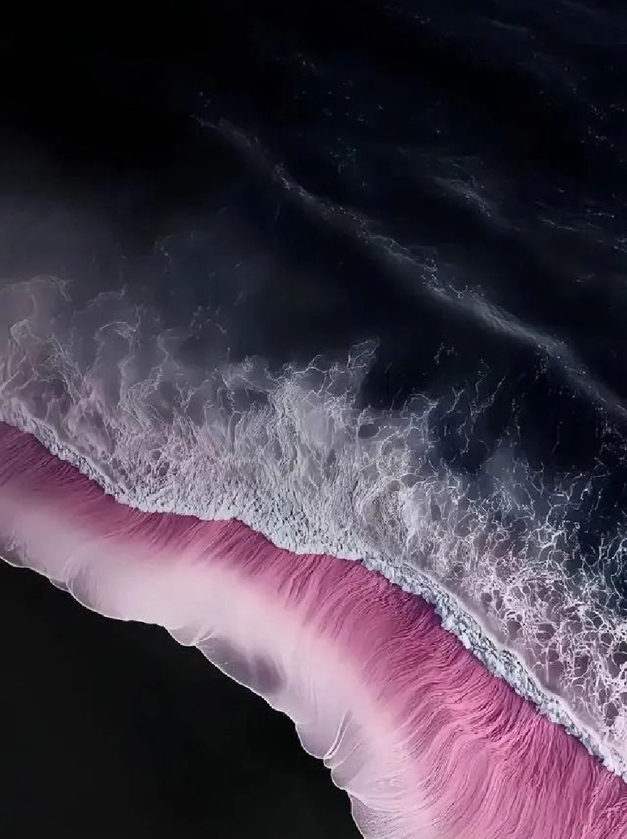 Русский промпт: A photograph taken from an aerial perspective, looking down at a vast expanse of ocean with dark, stormy skies. The foreground is dominated by a pink-tinted wave, with the ocean stretching out in front of it. The wave is foamy and turbulent, with white foam and spray visible on the surface. The sky is mostly dark, with some lighter clouds scattered throughout. The overall mood is dramatic and moody, with a sense of depth and movement. The photograph has a dreamy, ethereal quality. | Original prompt: A photograph taken from an aerial perspective, looking down at a vast expanse of ocean with dark, stormy skies. The foreground is dominated by a pink-tinted wave, with the ocean stretching out in front of it. The wave is foamy and turbulent, with white foam and spray visible on the surface. The sky is mostly dark, with some lighter clouds scattered throughout. The overall mood is dramatic and moody, with a sense of depth and movement. The photograph has a dreamy, ethereal quality.