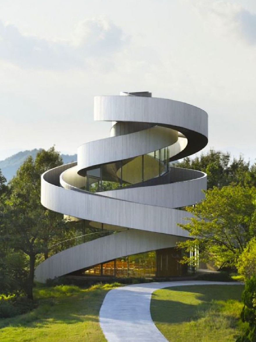 Русский промпт: A rendering of a modern, spiral-shaped building with a contemporary architectural design, located in a grassy area with a winding pathway leading up to it. The building has a white, corrugated metal exterior with glass windows that allow natural light to filter through, creating a bright and airy atmosphere. The sky is clear and blue, with a few clouds scattered across it, and the surrounding area is filled with lush green trees and shrubs. In the background, a distant mountain range can be seen. The image is framed by a bright, sunny day with a clear blue sky. | Original prompt: A rendering of a modern, spiral-shaped building with a contemporary architectural design, located in a grassy area with a winding pathway leading up to it. The building has a white, corrugated metal exterior with glass windows that allow natural light to filter through, creating a bright and airy atmosphere. The sky is clear and blue, with a few clouds scattered across it, and the surrounding area is filled with lush green trees and shrubs. In the background, a distant mountain range can be seen. The image is framed by a bright, sunny day with a clear blue sky.