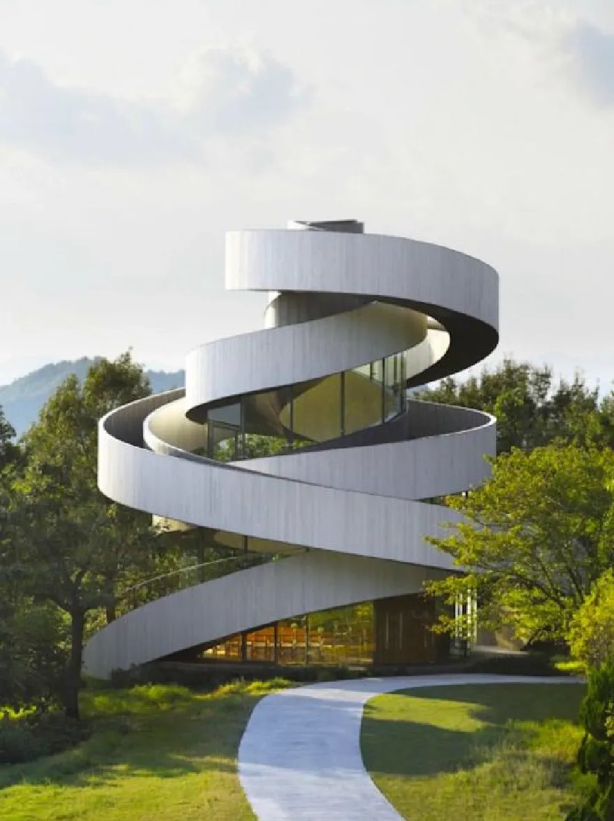 Русский промпт: A rendering of a modern, spiral-shaped building with a contemporary architectural design, located in a grassy area with a winding pathway leading up to it. The building has a white, corrugated metal exterior with glass windows that allow natural light to filter through, creating a bright and airy atmosphere. The sky is clear and blue, with a few clouds scattered across it, and the surrounding area is filled with lush green trees and shrubs. In the background, a distant mountain range can be seen. The image is framed by a bright, sunny day with a clear blue sky. | Original prompt: A rendering of a modern, spiral-shaped building with a contemporary architectural design, located in a grassy area with a winding pathway leading up to it. The building has a white, corrugated metal exterior with glass windows that allow natural light to filter through, creating a bright and airy atmosphere. The sky is clear and blue, with a few clouds scattered across it, and the surrounding area is filled with lush green trees and shrubs. In the background, a distant mountain range can be seen. The image is framed by a bright, sunny day with a clear blue sky.