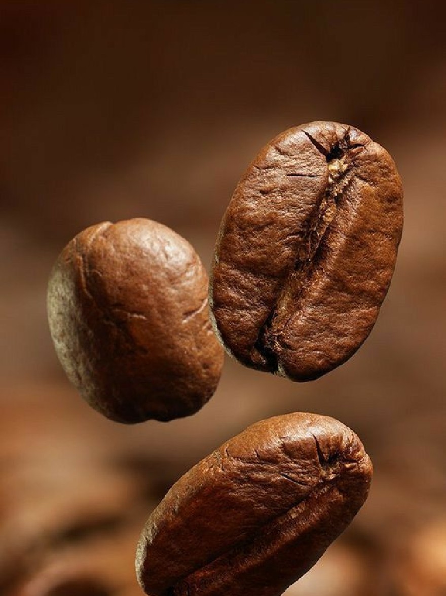 Русский промпт: Фотография трех жареных кофейных зерен в воздухе, с размытым темно-коричневым фоном. Бобы расположены в треугольной формировании, с самым большим в центре и двумя меньшими с обеих сторон. Текстура бобов грубая и неровная, с некоторыми областями с трещинами и чипсами. Освещение мягкое и естественное, подчеркивая темно -коричневый цвет бобов. Фокус избирательно помещается на бобы, что делает их центром изображения. | Original prompt: A photograph of three roasted coffee beans in mid-air, with a blurred, dark brown background. The beans are arranged in a triangular formation, with the largest one in the center and two smaller ones on either side. The texture of the beans is rough and uneven, with some areas having cracks and chips. The lighting is soft and natural, highlighting the beans' deep brown color. The focus is selectively placed on the beans, making them the focal point of the image.