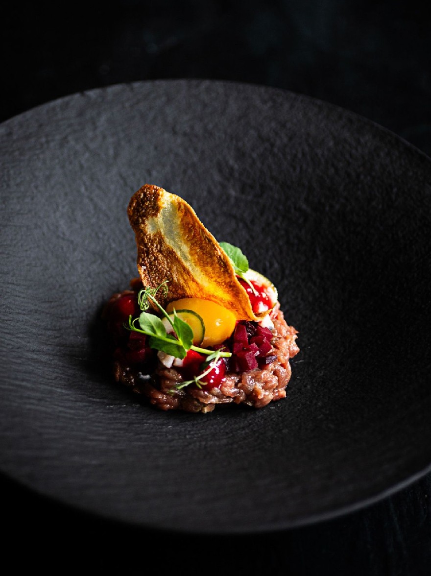 Русский промпт: Фотография тарелки с едой на темной черной тарелке, установленной на темном фоне. Пластина имеет прямоугольную форму и имеет темную текстурированную поверхность. На вершине тарелки наверху есть кусок жареного яйца, окруженное кроватью ризотто с пюре из свеклы и дождь томатного соуса. Ризотто украшено брызгом из листьев мяты. Яйцо приготовлено до совершенства, с золотисто-коричневой корочкой и сочным, жидким желтком. Блюдо выглядит аппетитным и визуально привлекательным. Освещение мягкое и естественное, подчеркивая текстуру ризотто и яркие цвета ингредиентов. | Original prompt: A photograph of a plate of food on a dark black plate, set against a dark background. The plate is rectangular in shape and has a dark, textured surface. On top of the plate, there is a piece of fried egg on top, surrounded by a bed of risotto with beetroot puree and a drizzle of tomato sauce. The risotto is garnished with a sprinkle of mint leaves. The egg is cooked to perfection, with a golden-brown crust and a juicy, runny yolk. The dish looks appetizing and visually appealing. The lighting is soft and natural, highlighting the texture of the risotto and the vibrant colors of the ingredients.