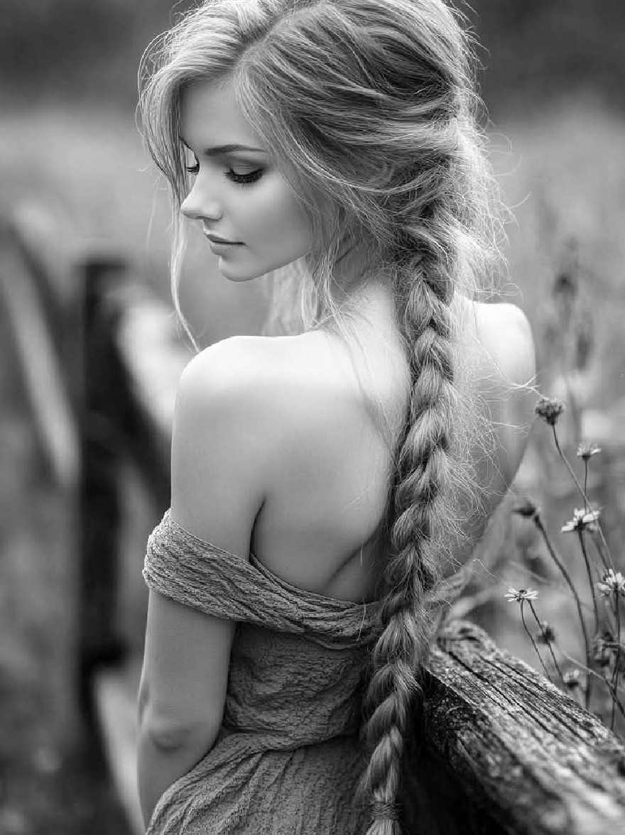 Русский промпт: Черно-белая фотография молодой женщины с длинными волнистыми светлыми волосами, приготовленными в боковой косичке с вязаным платьем с открытыми плечами. Она стоит на улице, прислонившись к деревянному забору, глядя через плечо с созерцательным выражением. Фон размыт, что предлагает естественную обстановку с зеленью и полевыми цветами. Освещение мягкое и естественное, подчеркивая ее нежные черты и текстуру ее платья. Общее настроение мирное и безмятежное. | Original prompt: A black and white photograph of a young woman with long, wavy blonde hair styled in a side braid, wearing a knitted off-the-shoulder dress. She is standing outdoors, leaning against a wooden fence, looking over her shoulder with a contemplative expression. The background is blurred, suggesting a natural setting with greenery and wildflowers. The lighting is soft and natural, highlighting her delicate features and the texture of her dress. The overall mood is peaceful and serene.