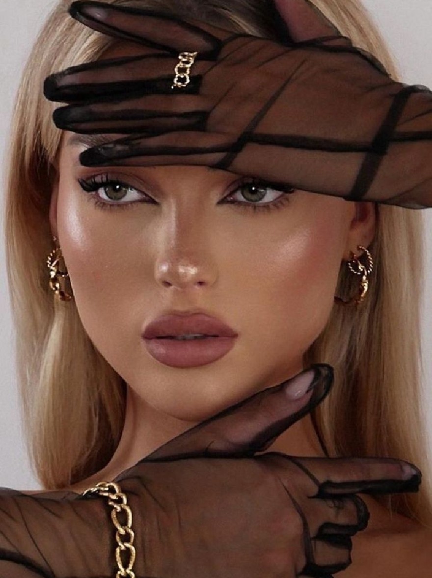 Русский промпт: Photo of a woman with long blonde hair, wearing black sheer gloves and gold hoop earrings. She has a neutral expression and is looking directly at the camera. Her hands are resting on her head, covering her eyes. She is wearing a gold chain bracelet on her left wrist. The background is a plain white wall. The lighting is soft and natural, highlighting her face and the texture of her gloves. | Original prompt: Photo of a woman with long blonde hair, wearing black sheer gloves and gold hoop earrings. She has a neutral expression and is looking directly at the camera. Her hands are resting on her head, covering her eyes. She is wearing a gold chain bracelet on her left wrist. The background is a plain white wall. The lighting is soft and natural, highlighting her face and the texture of her gloves.